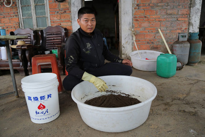 Worker mixing fish feed