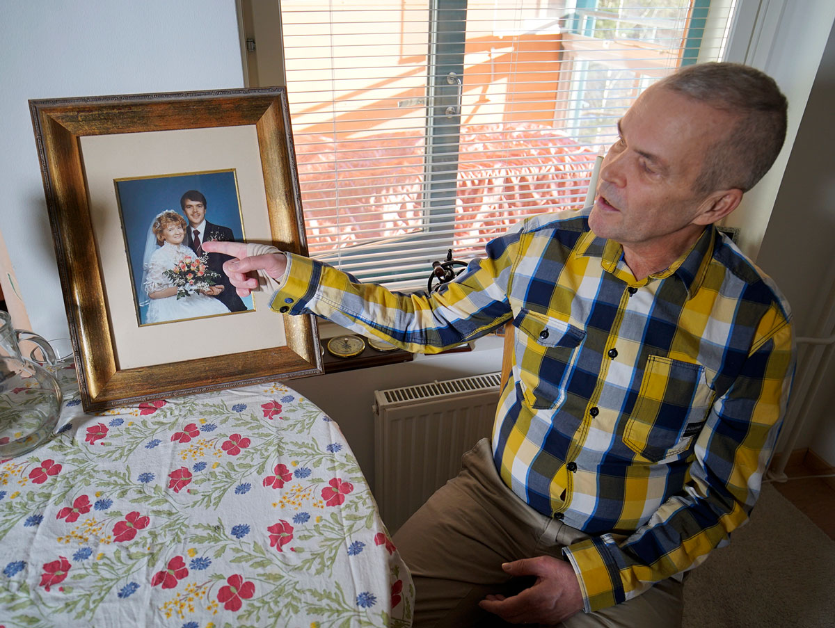 A man points to a wedding photo.