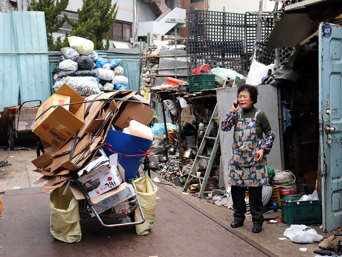 A woman talking on her phone outside a collection depot.