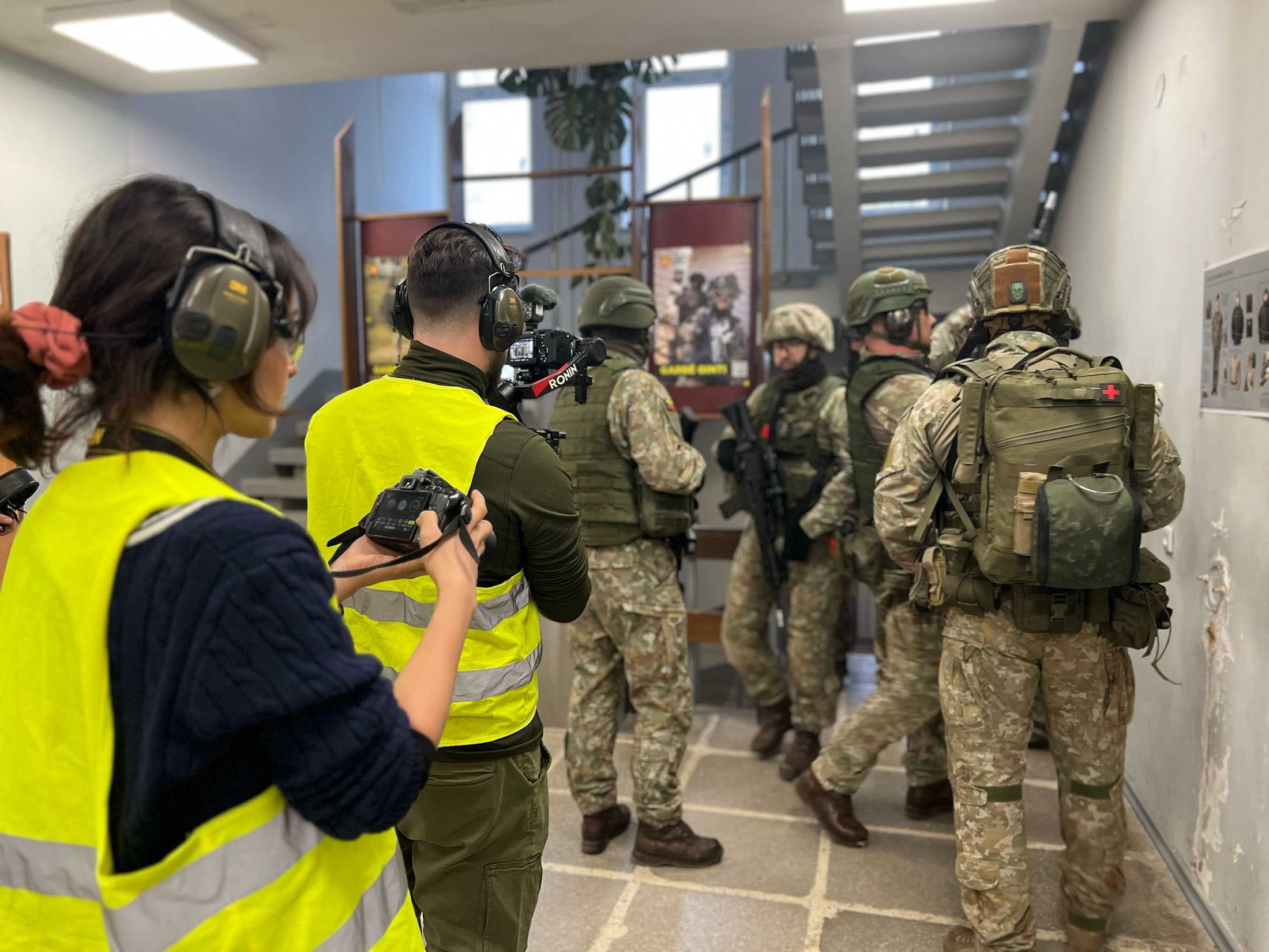 Two people photographing a military training exercise