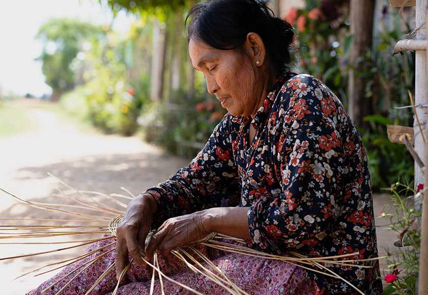 A woman weaving a basket.